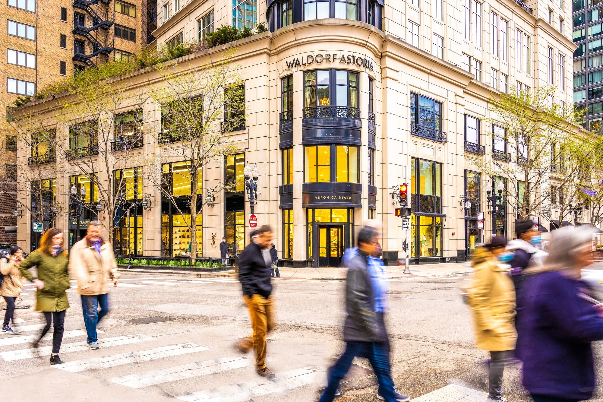 Waldorf Astoria Hotel entrance with pedestrians crossing the street.