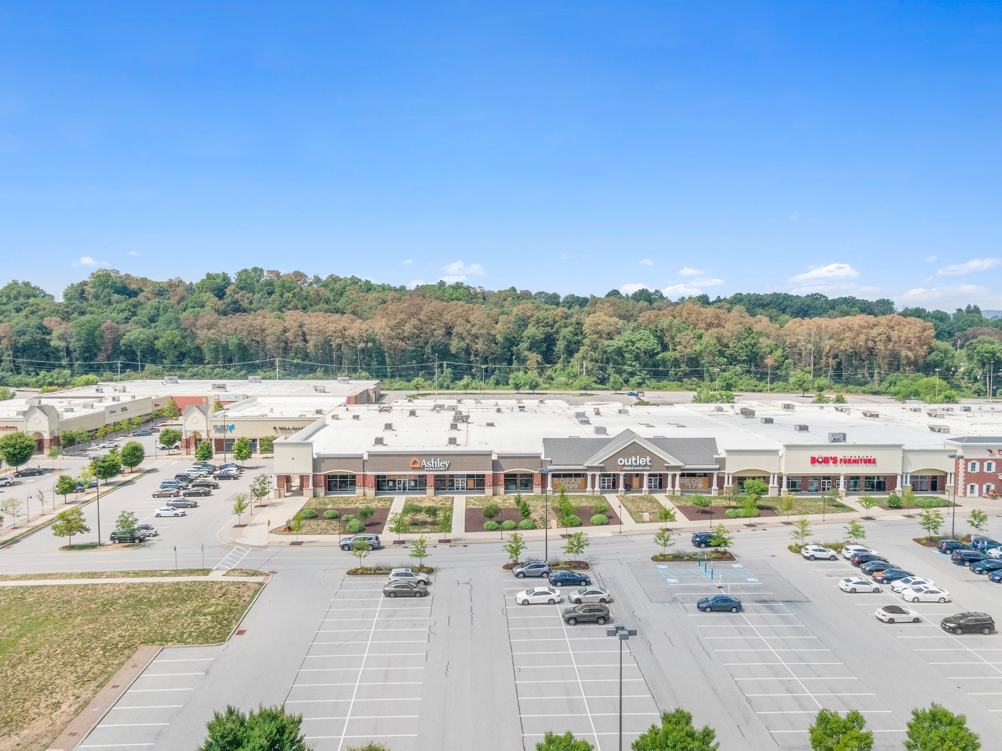 Aerial view of a strip mall with a large parking lot.