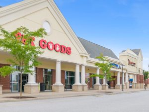Exterior view of a retail building with "Goods" signage.