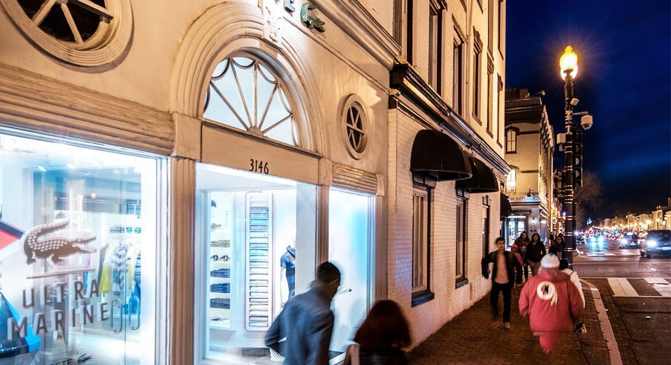 Exterior view of a brightly lit storefront at night.