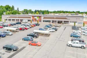 Aerial view of a shopping center parking lot with many cars.