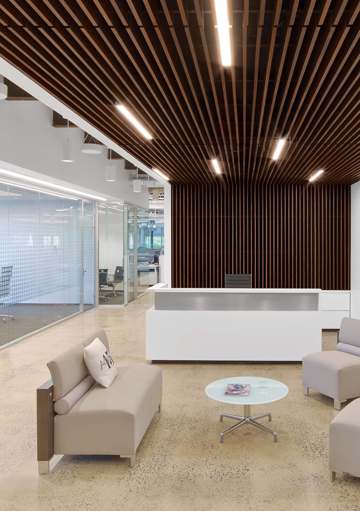 Modern office reception area with wood slat ceiling and wall.