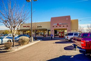 Exterior view of a shopping center with several stores.