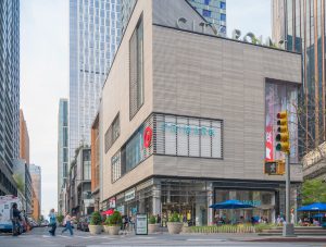 Modern corner building with shops and restaurants.