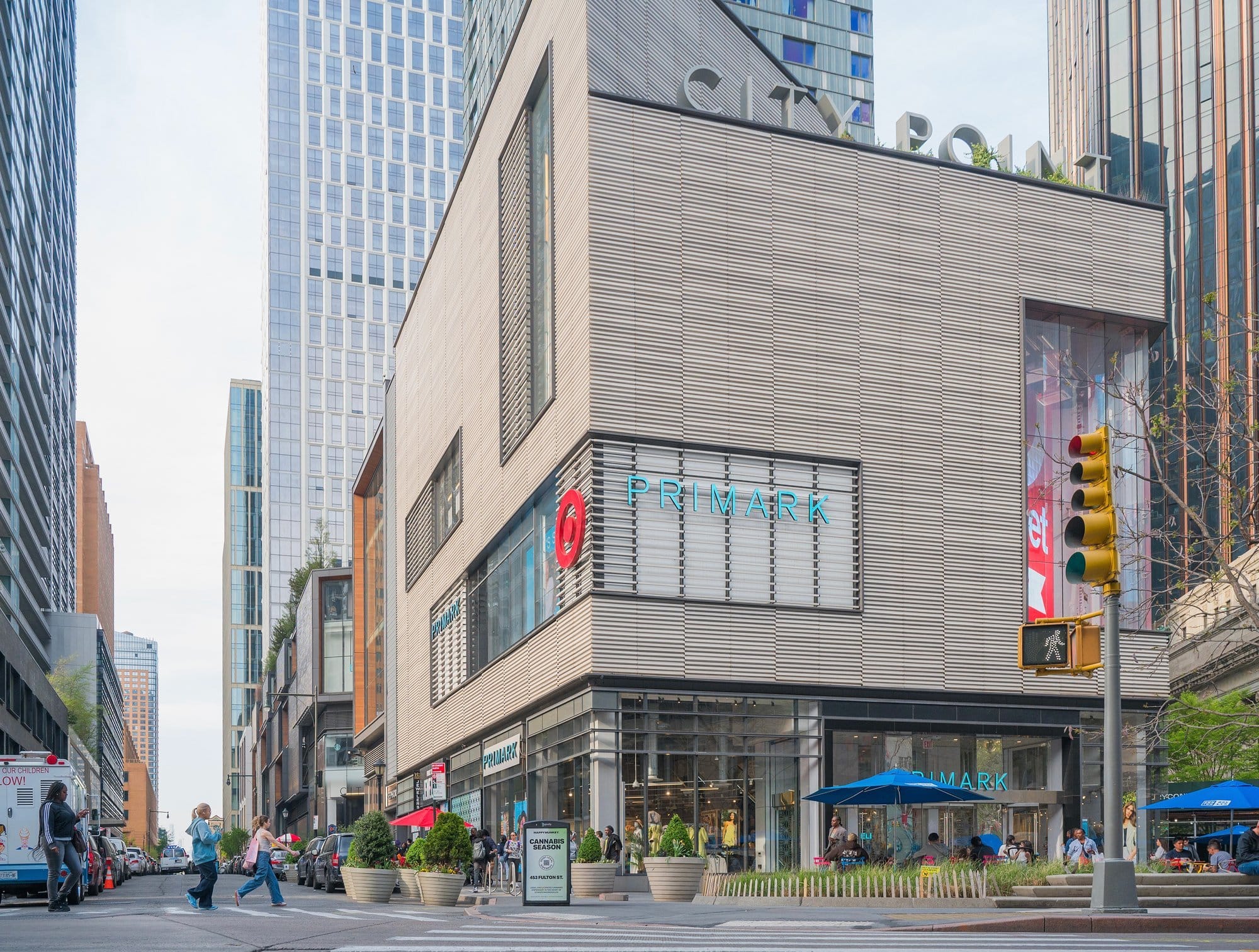 Modern corner building with shops and restaurants.
