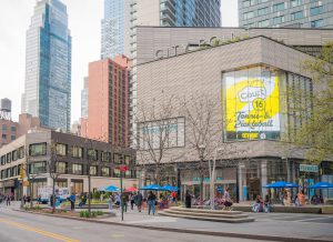 City Centre mall with people sitting outside and tall buildings in the background.