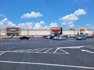 A large, mostly empty parking lot in front of a partially visible building with a "Hobby Lobby" sign.