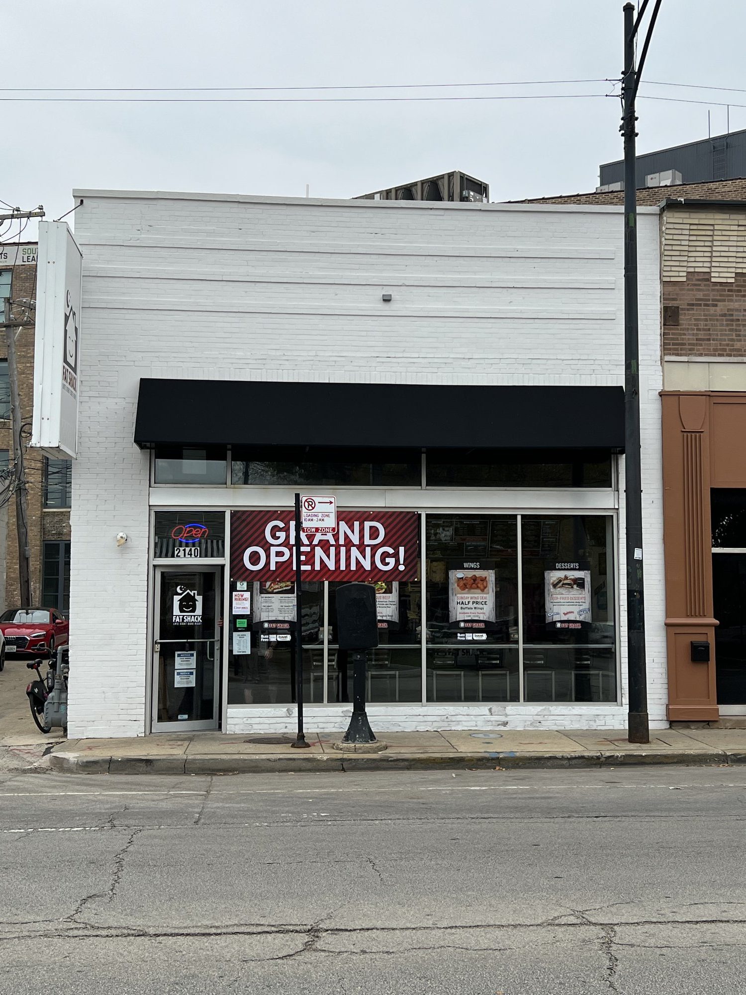 A storefront with a "Grand Opening" banner.