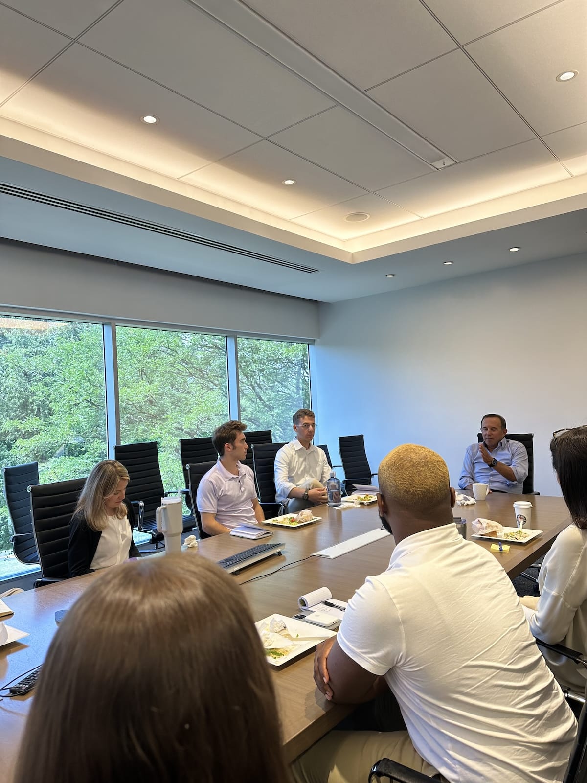 Group of people seated around a conference table in a modern office.