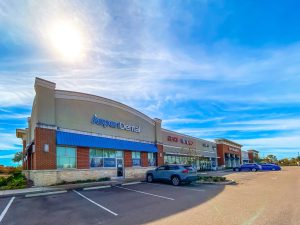 Exterior view of a strip mall with a Regions Bank and other businesses.