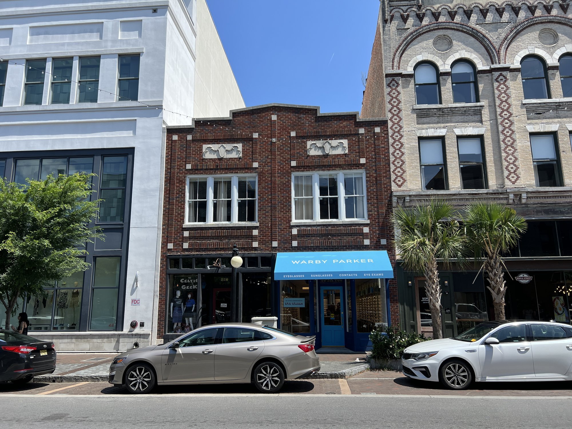 Two-story brick commercial building with blue awning.