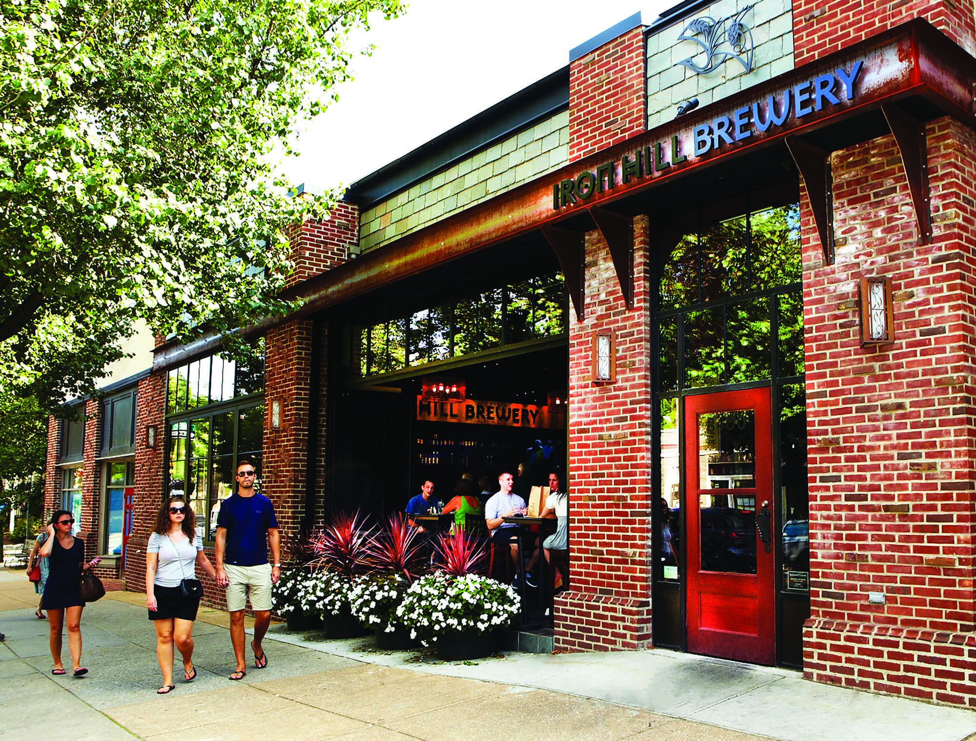 Couple walking past a brick brewery building.