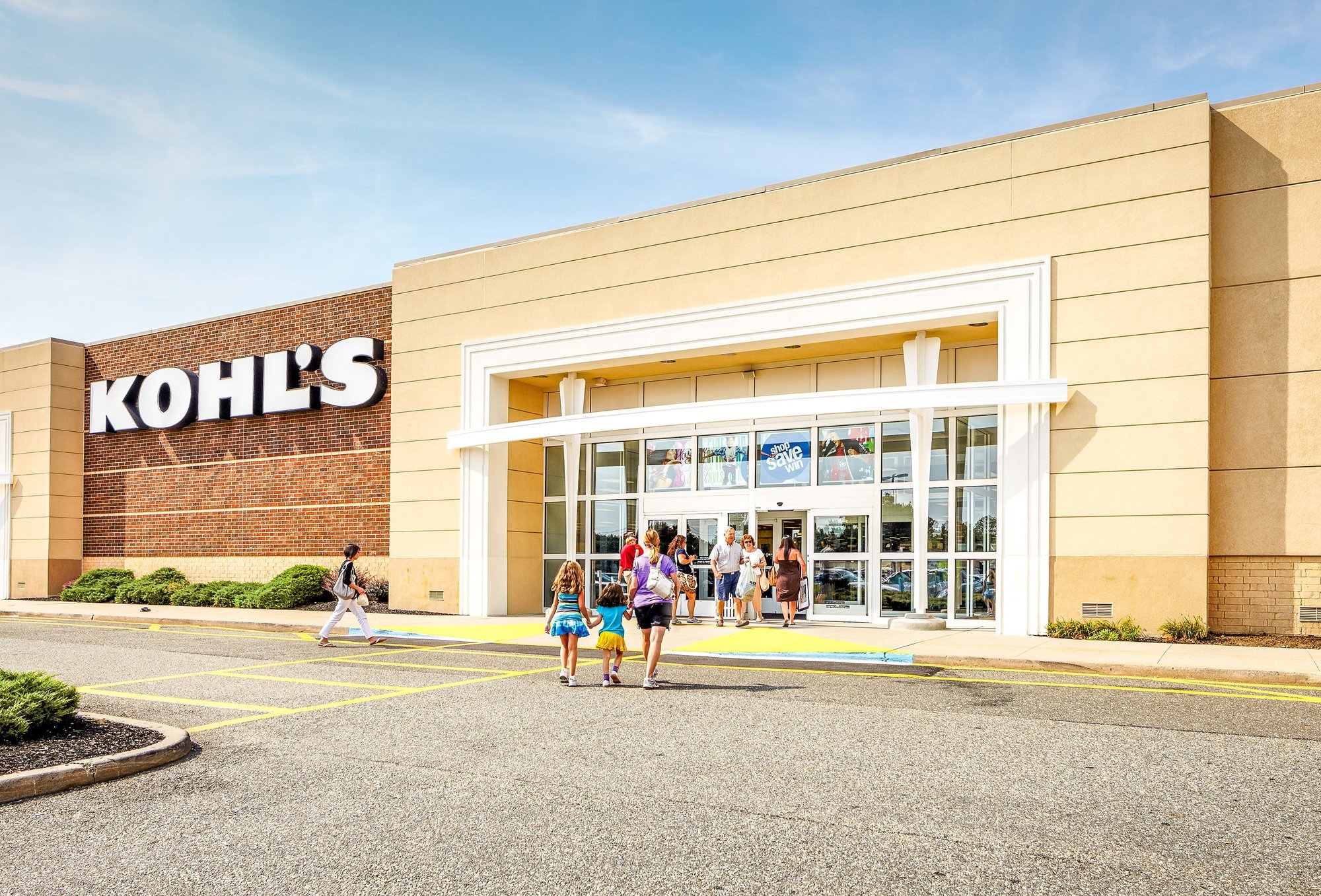Kohl's department store exterior with shoppers entering.