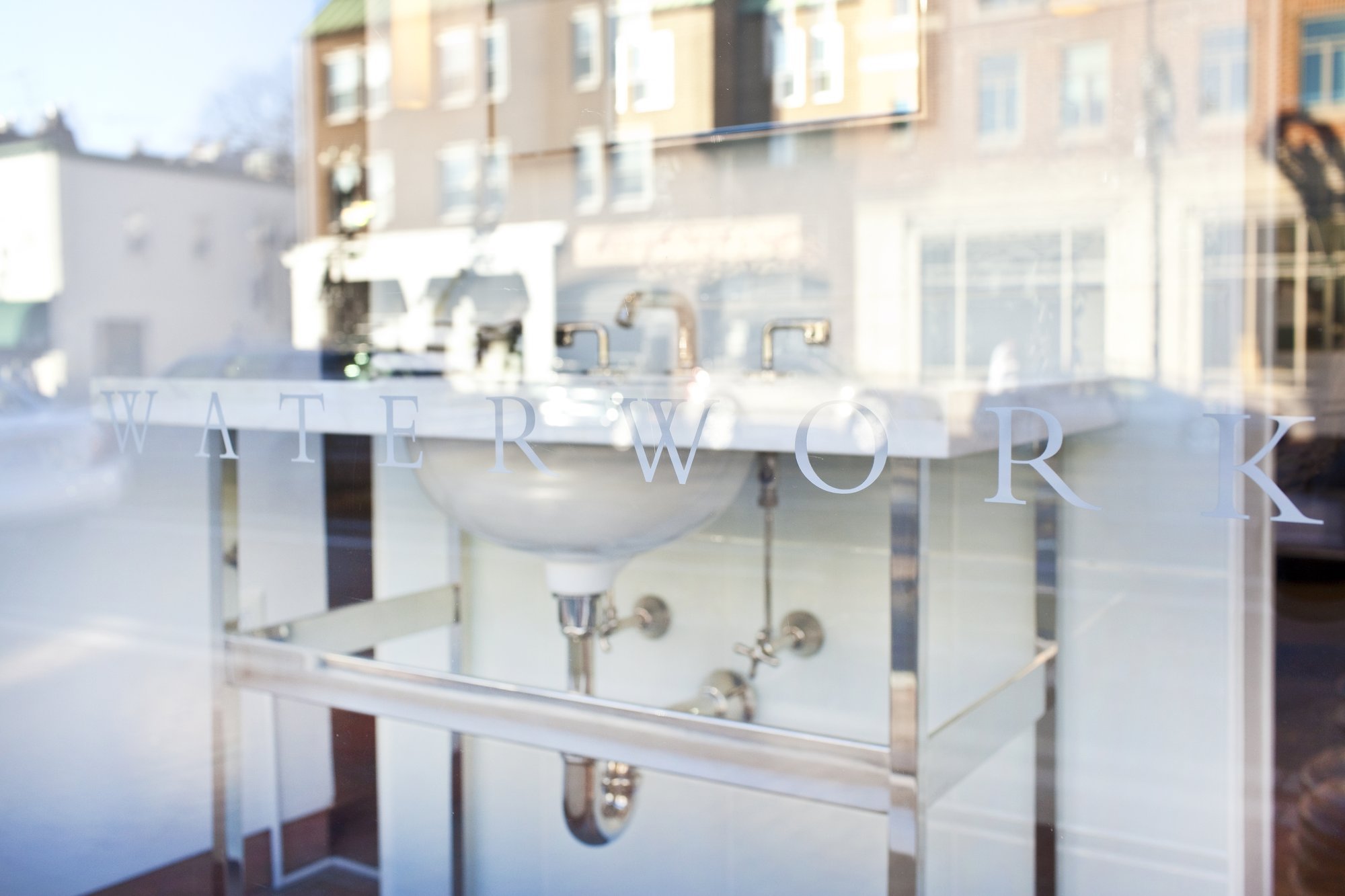 White bathroom vanity with sink in storefront window.