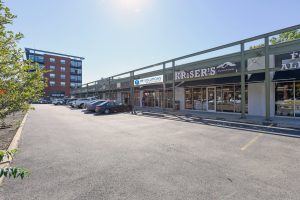 Exterior view of a strip mall with several businesses and a parking lot.