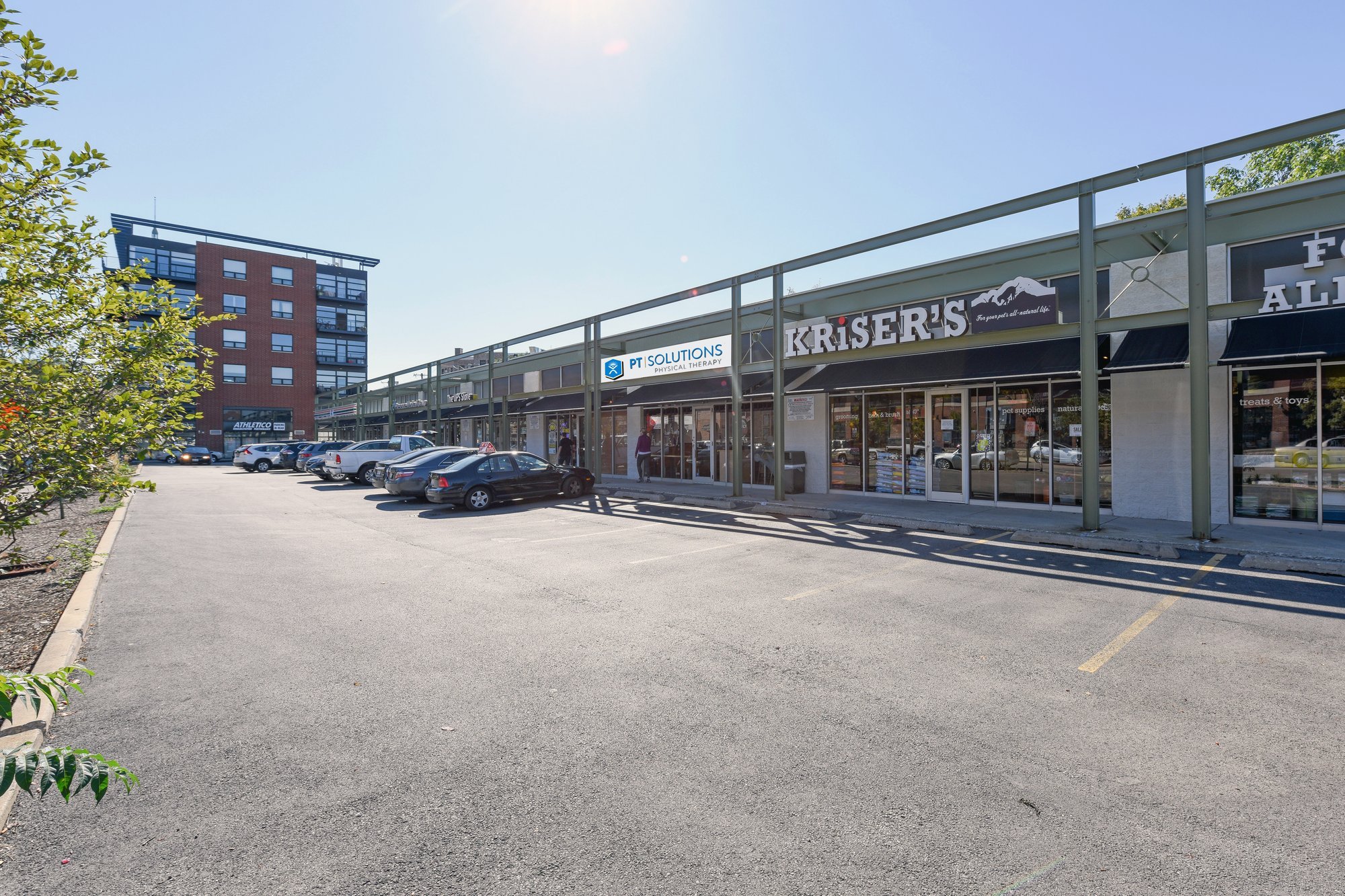 Exterior view of a strip mall with several businesses and a parking lot.
