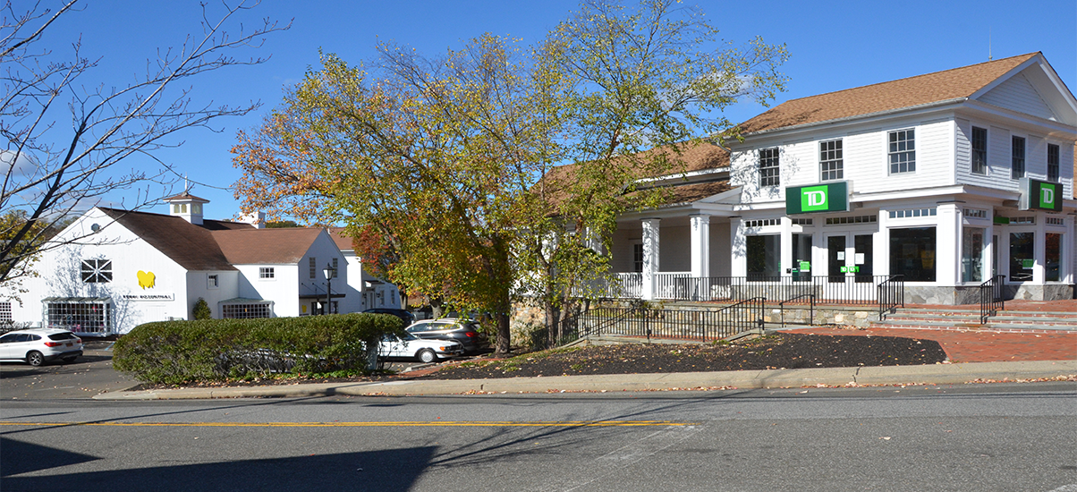 Exterior view of a commercial building and adjacent smaller buildings.