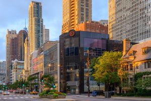 City street scene with modern and older buildings at sunrise.