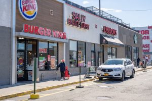 Exterior view of a strip mall with Burger King, Sally Beauty, and Jacques stores.