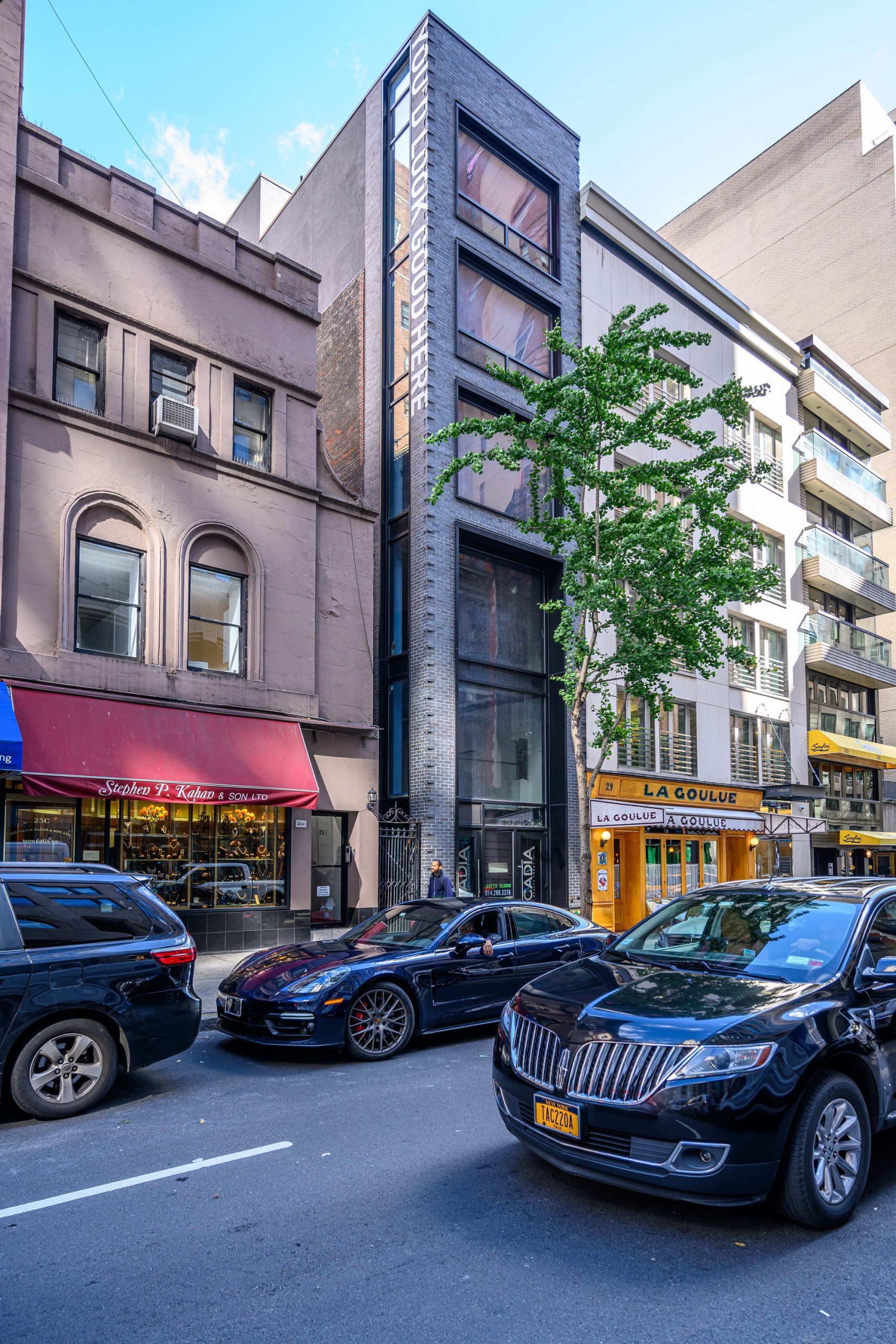 Modern building between older buildings on a city street.