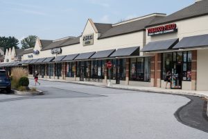 Exterior view of a shopping center with several stores.