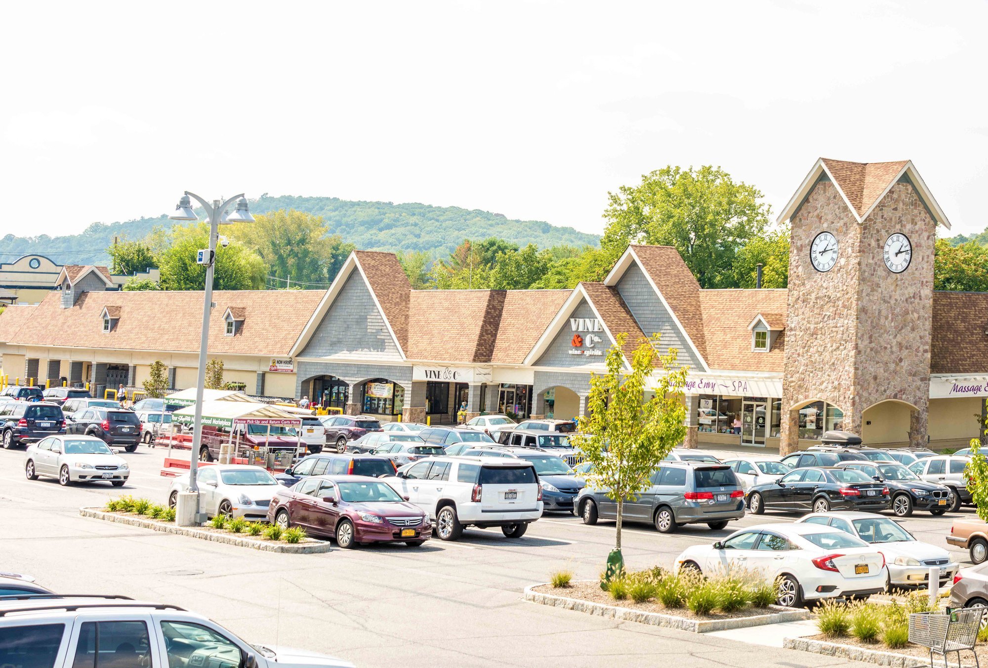 Exterior view of a shopping center with cars in the parking lot.