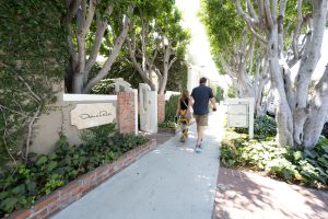 Couple walking down a path to the entrance of Charisma hotel.