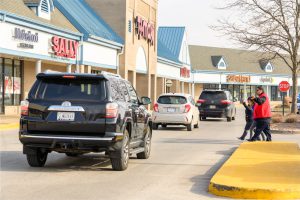 Cars parked in a strip mall parking lot.
