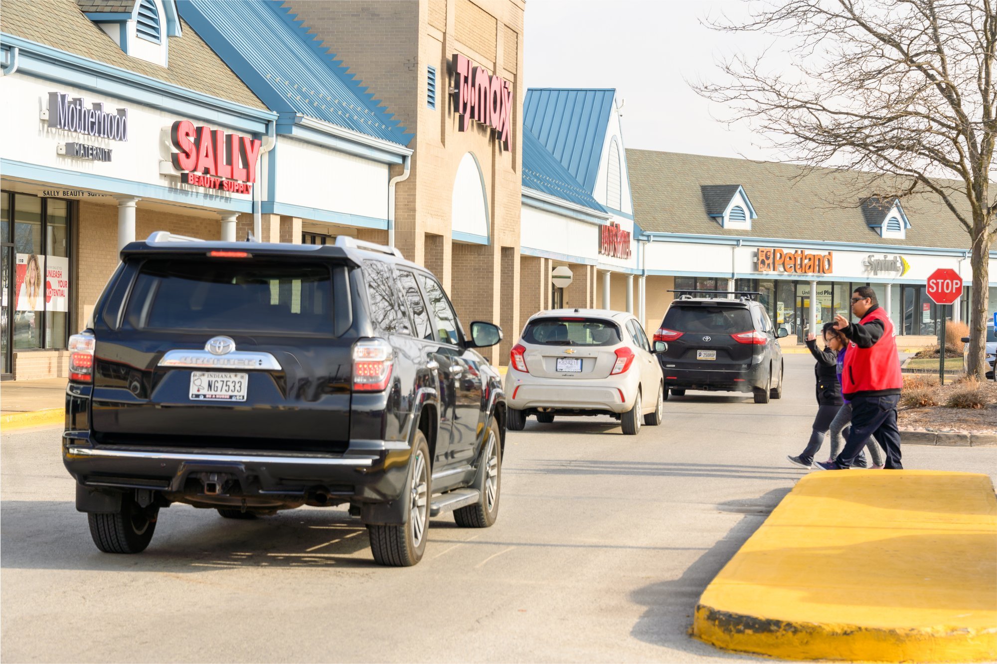 Cars parked in a strip mall parking lot.