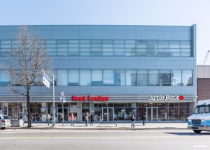 Exterior view of a building with a Best Buy and Apple store at street level.