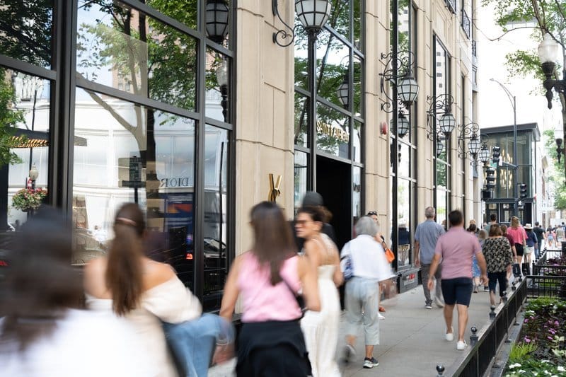 People walking past a city storefront.