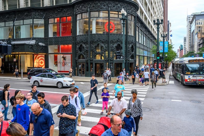Pedestrians crossing a city street in front of a Target store.