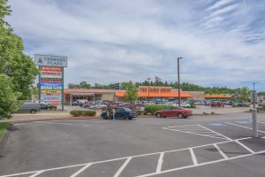 Strip mall with parking lot and several businesses.