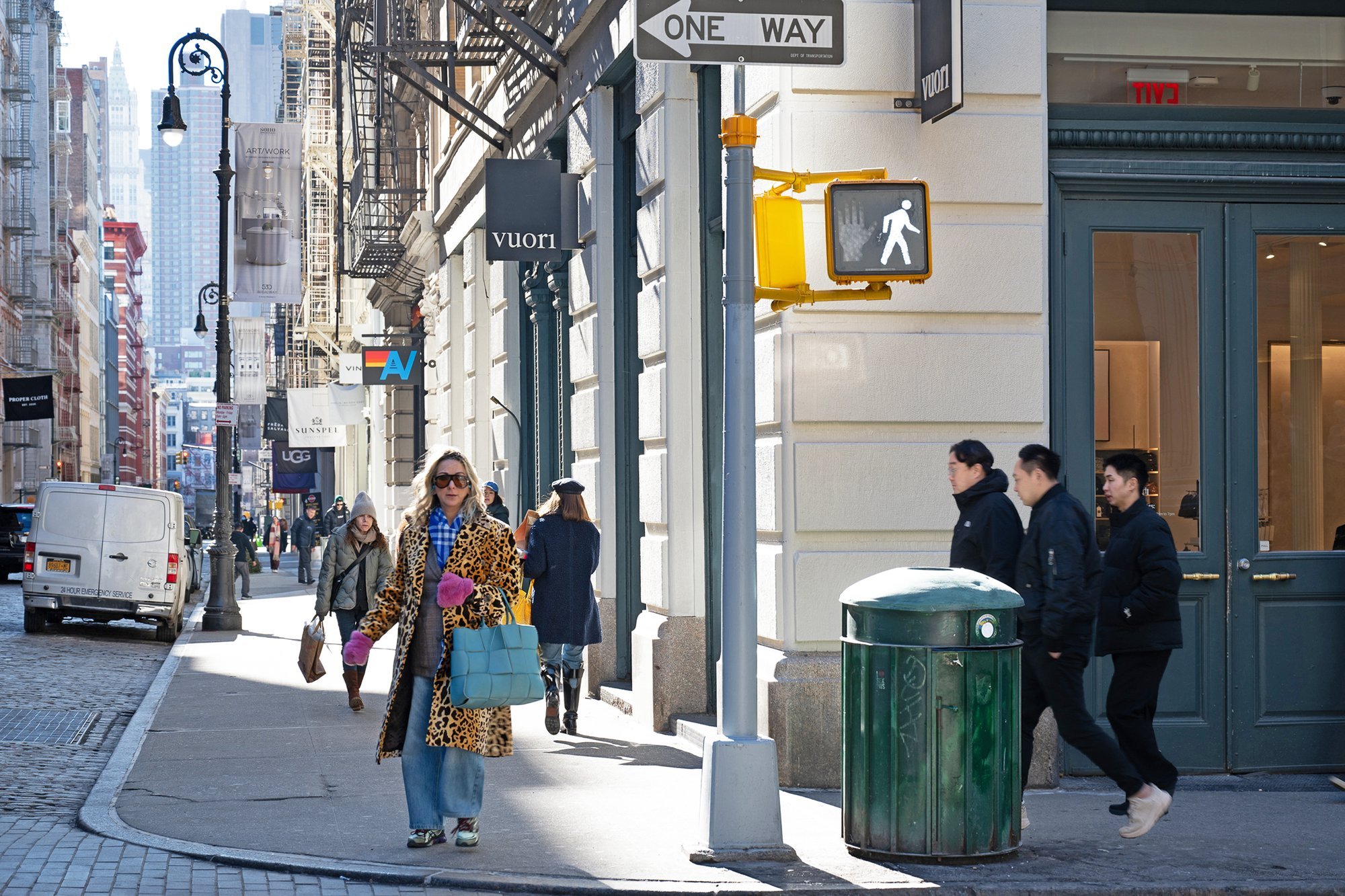 Pedestrians walking on a city sidewalk.