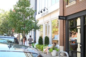 Upscale shops and pedestrians on a city street.