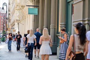 People walking past a store on a city street.