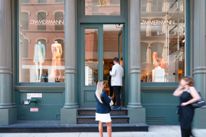People standing outside a green storefront.