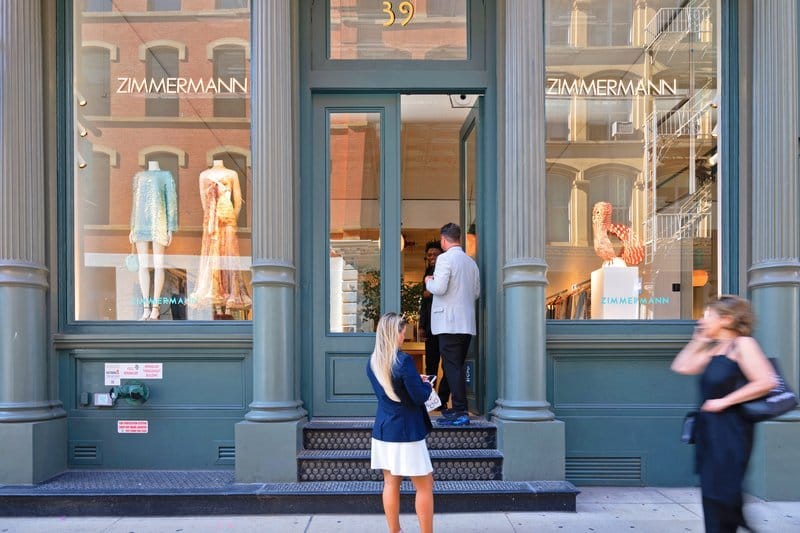 Exterior view of a store with people standing at the entrance.
