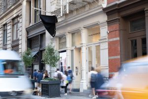 Exterior view of a modern storefront in New York City with people walking by.