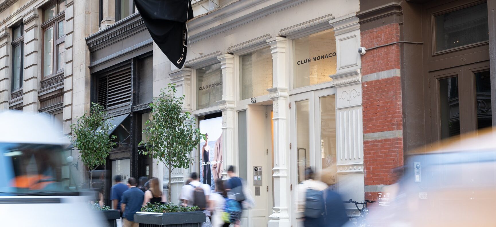 Exterior view of a modern storefront in New York City with people walking by.