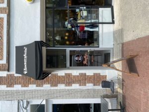Exterior view of a storefront with mannequins in the window.