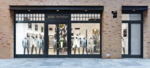 People walking past shops on a city street.