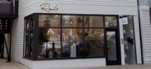 Exterior view of a shoe store with blue doors and stained glass windows.