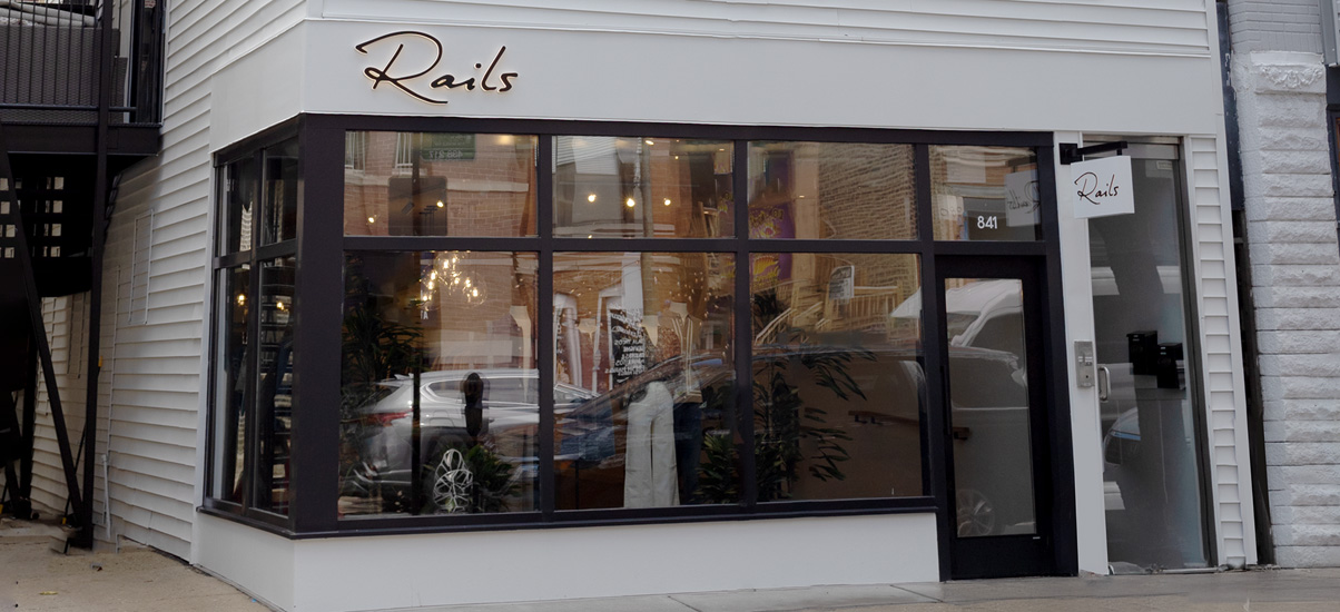 Exterior view of a shoe store with blue doors and stained glass windows.