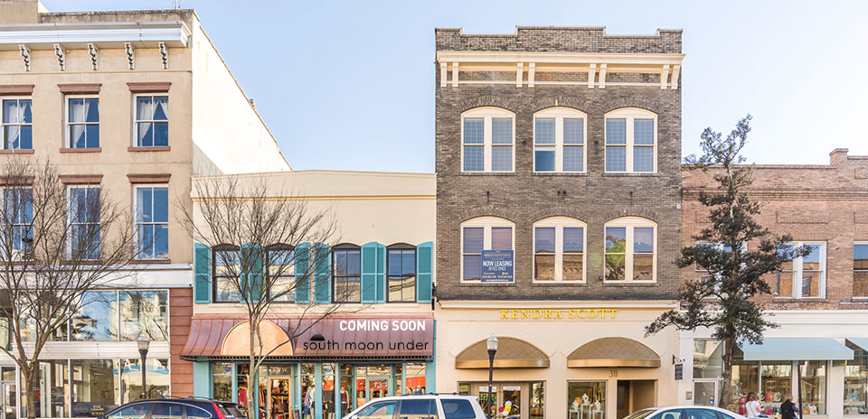Two-story commercial buildings on a city street.