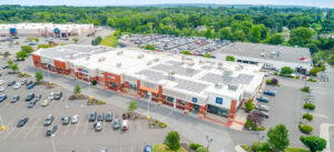 Aerial view of a shopping center parking lot with many cars.
