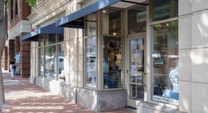 Exterior view of a storefront with a blue awning.