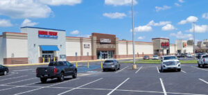 Shopping center parking lot with several stores visible.