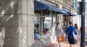 Storefront with pedestrians walking by.