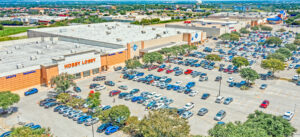 Aerial view of a large retail shopping center parking lot with a Hobby Lobby store.
